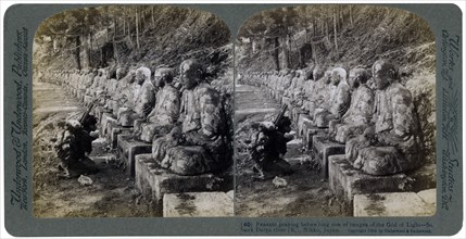 Peasant praying before a row of statues of the God of Light, Daiya river, Nikko, Japan, 1904.Artist: Underwood & Underwood