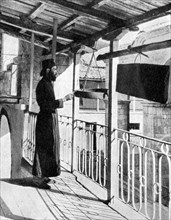 Monk sounding the call to prayer on a gong, Greece, 1936.Artist: Nomias