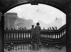 A man and a boy feeding the birds by Blackfriars Bridge, London, 1926-1927. Artist: Unknown