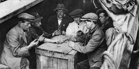 A bargee and his mates play dominoes in the hold of a canal boat, 1926-1927. Artist: Unknown