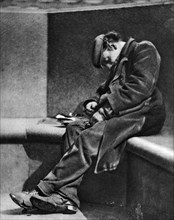 A man sleeping on Blackfriars Bridge, London, 1926-1927.Artist: Walter Benington
