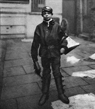 'Scavenger boy', who cleans up horse droppings in the road, London, 1926-1927. Artist: Unknown