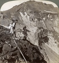 Peering from the lava encrusted rim down into Mount Fuji's (Fujiyama's) crater, Japan, 1904.Artist: Underwood & Underwood