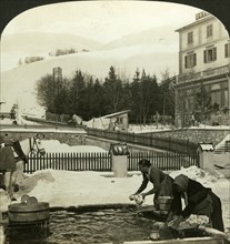 Women washing clothes at the public fountain in midwinter, Zuoz, Switzerland. Artist: HC White