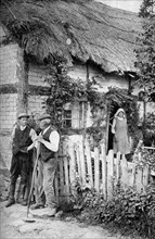 Two men chatting outside a cottage, near Lucton, Herefordshire, c1922.Artist: AW Cutler