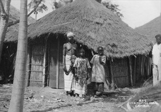 A family in front of their home, Gambia, 20th century. Artist: Unknown