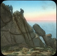 Climbing the Logan Rock, near Treen, Cornwall, late 19th or early 20th century.  Artist: Church Army Lantern Department