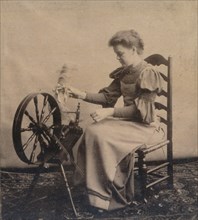 A lady at a spinning wheel c1900. Artist: Unknown