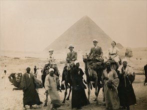 British tourists seated on camels in front of The Great Pyramid, Giza, Egypt, 1936. Artist: Unknown