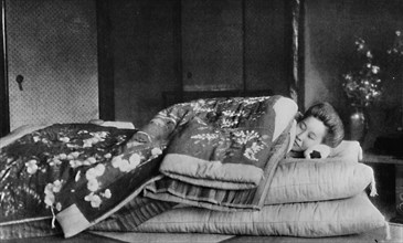 'Saki, the housekeeper sleeps on a mattress with hard pillow under a quilted kimono', c1900, (1921). Artist: Julian Leonard Street.