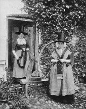 Welsh women with a spinning wheel, 1912. Artist: Unknown.