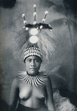 A Samoan woman wearing a collar of cachalots' teeth and a ceremonial headdress, 1902. Artist: Josiah Martin.