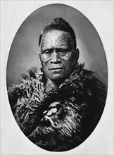 A Maori chief with elaborately tattooed face and weather cloak, 1902. Artist: Josiah Martin.