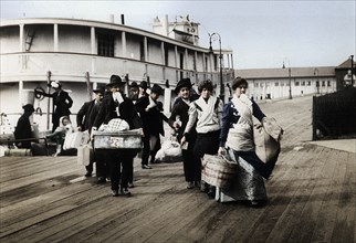 Immigrants to the USA landing at Ellis Island, New York, c1900. Artist: Unknown.