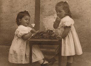 'Two young girls by a table', 1937.  Artist: Unknown.