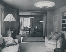 'Dining and living room, divided only by heavy curtains in an attractive modern weave', 1942. Artist: Unknown.