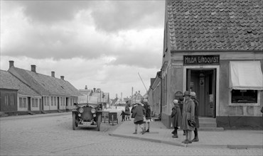 Parked car and children on a street corner, Landskrona, Sweden, 1925. Artist: Unknown