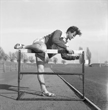 Adjusting a hurdle on an athletics track, Landskrona, Sweden, 1955. Artist: Unknown