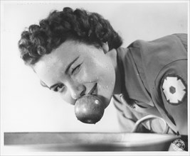 Woman soldier bobbing for apples, Fort Sheridan, Illinois, USA, 1943. Artist: US Army