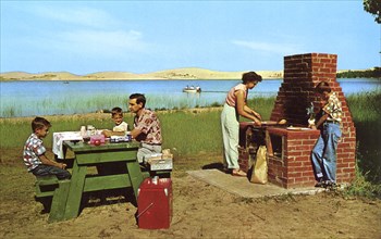 Family having a picnic on the beach by a lake, Michigan, USA, 1955. Artist: Unknown