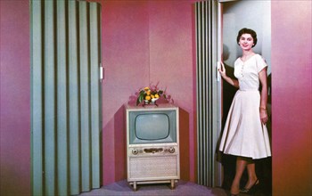Woman walking into a room with a television, Janesville, Wisconsin, USA, 1955. Artist: Unknown