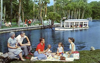 A family having a picnic beside the water, Silver Springs, Florida, USA, 1959. Artist: Mozert