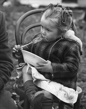 Gypsy girl eating, 1960s.