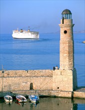 Venetian lighthouse and the ferry to Piraeus, Rethymnon, Crete, Greece.