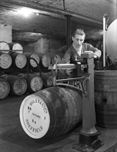 Weighing barrels of blended whisky at Wiley & Co, Sheffield, South Yorkshire, 1960. Artist: Michael Walters