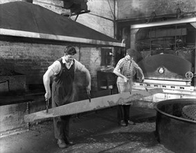 Heat treating a two metre saw blade, Slack Sellars & Co Ltd, Sheffield, South Yorkshire, 1963. Artist: Michael Walters