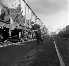 Final adjustments to a rail truck hauling coal from Lynemouth Colliery, Northumberland, 1963.  Artist: Michael Walters