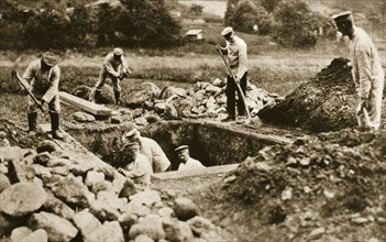 Digging mass graves behind the German lines, World War I, c1914-c1918. Artist: Unknown