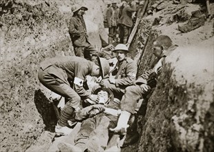 Red Cross men in the trenches tend a wounded man, Somme campaign, France, World War I, 1916. Artist: Unknown