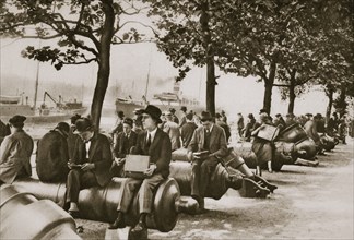 City workers lunching at Tower wharf, seated on old cannons, c1920s-c1930s. Artist: Unknown