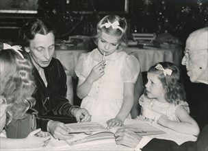 Crown Princess Louise reads a fairy tale to the princesses and King Gustav V of Sweden, 1940s. Artist: Karl Sandels