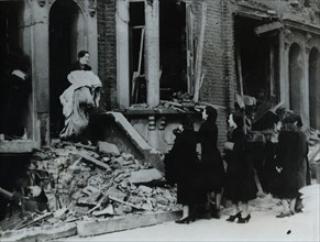 A woman collects her belongings from a bombed house, London, World War II, c1940-c1945. Artist: Unknown