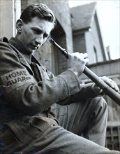 British Home Guard soldier cleaning his rifle, World War II, c1940-c1944. Artist: Unknown