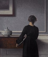 Interior with Young Woman from Behind. Artist: Hammershøi, Vilhelm (1864-1916)