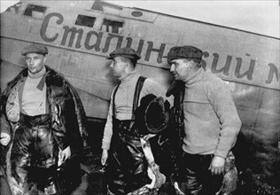 Alexander Belyakov, Georgiy Baidukov and Valery Chkalov by their plane on June 20, 1937. Artist: Anonymous
