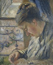 Mme Pissarro sewing beside a Window, c1877. Creator: Camille Pissarro.