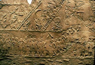 Assyrian warriors and besieging and destroying a city, in the lower register, capturing prisoners.