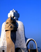 Detail of the chimneys of La Pedrera or Mila House with the Sagrada Familia at background, work b?