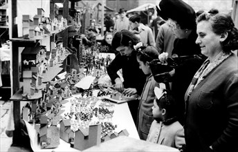Christmas fair in the Cathedral square in Barcelona, in the foreground manger figures in a shop a?