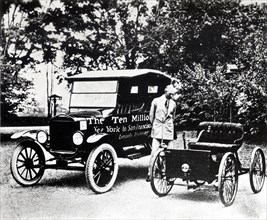 Henry Ford with old models of the Ford trademark.