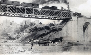Train crossing the bridge over the Sil river passing through Ponferrada, postcard 1910s.