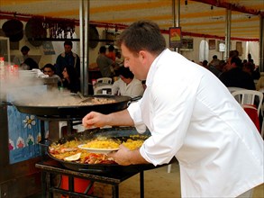 Mediterranean cuisine, chef preparing a paella, Feria de Abril (April Fair) 2002.