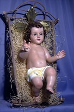 Figure of baby Jesus in the crib.