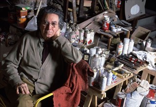 Antoni Tapies (1932-2012), Catalan painter in his studio surrounded by paintings and brushes.
