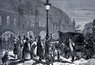 People around a new electrical lamppost in the train station of Friedrichstandt, engraving from 1?
