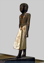Figurine of a man for a tomb, made of polychromed wood, side view.